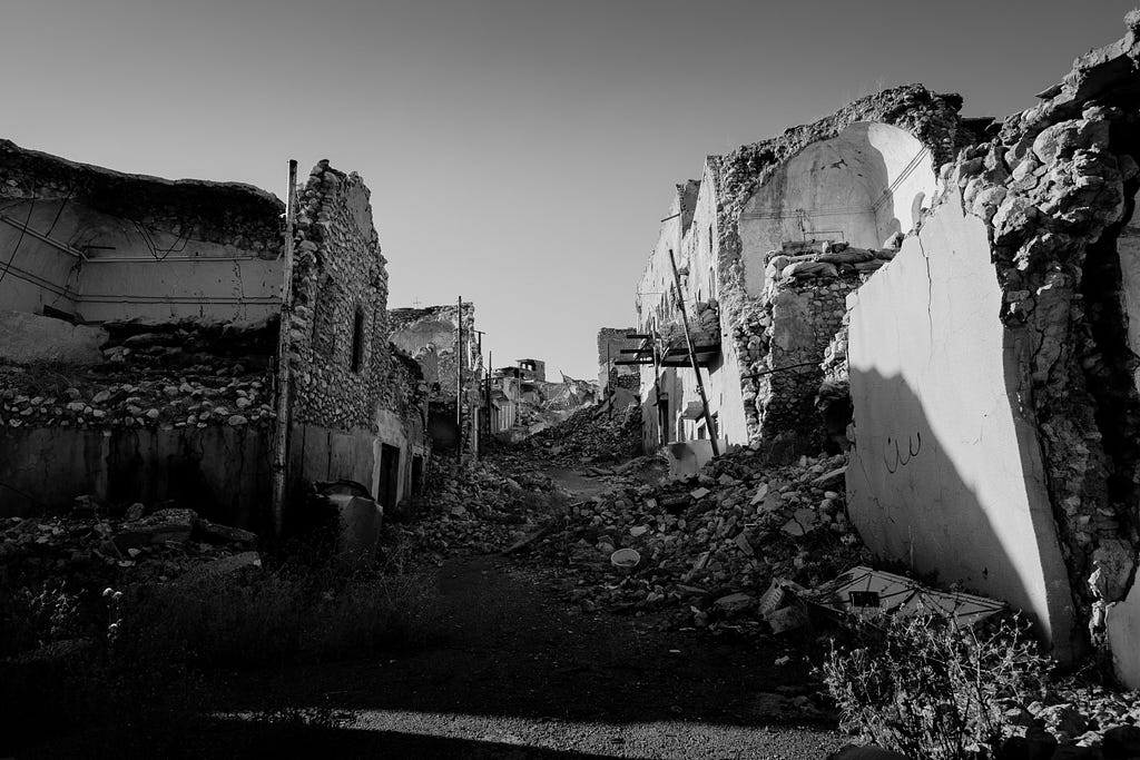 A black and white image of destroyed buildings and rubble