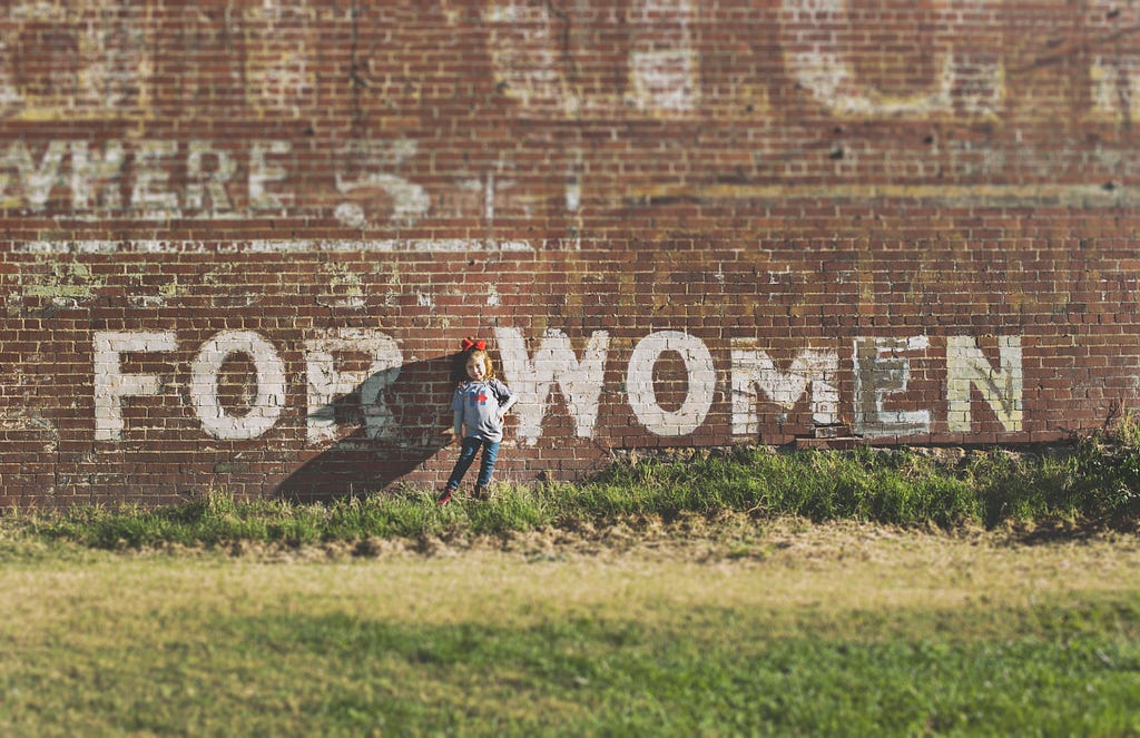 Grafitti of the words ‘for women’ on a brick wall