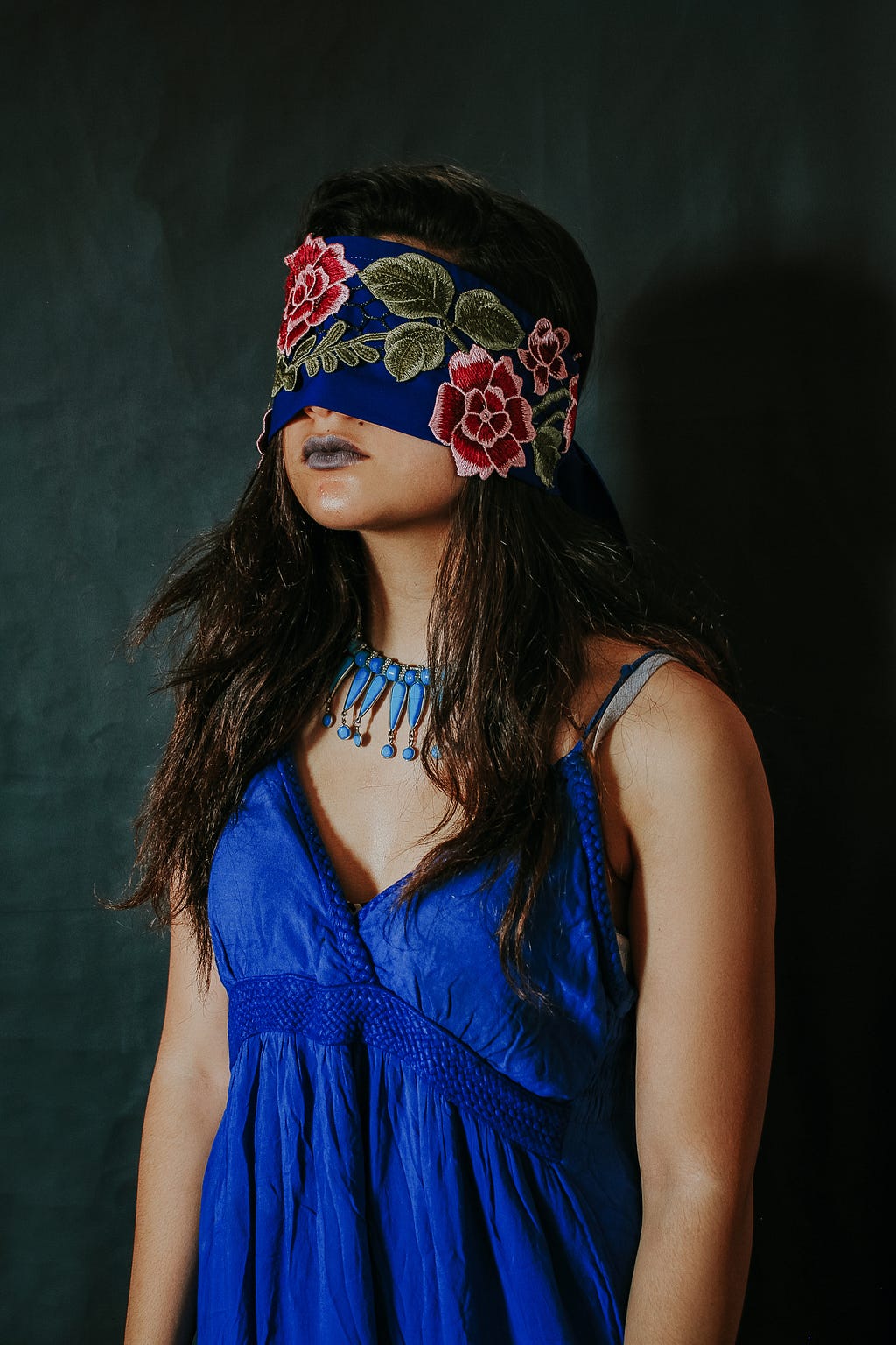 Woman in a blue dress blindfolded