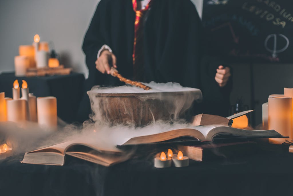 A smoking pot in which a magic potion is being created on a table with books.