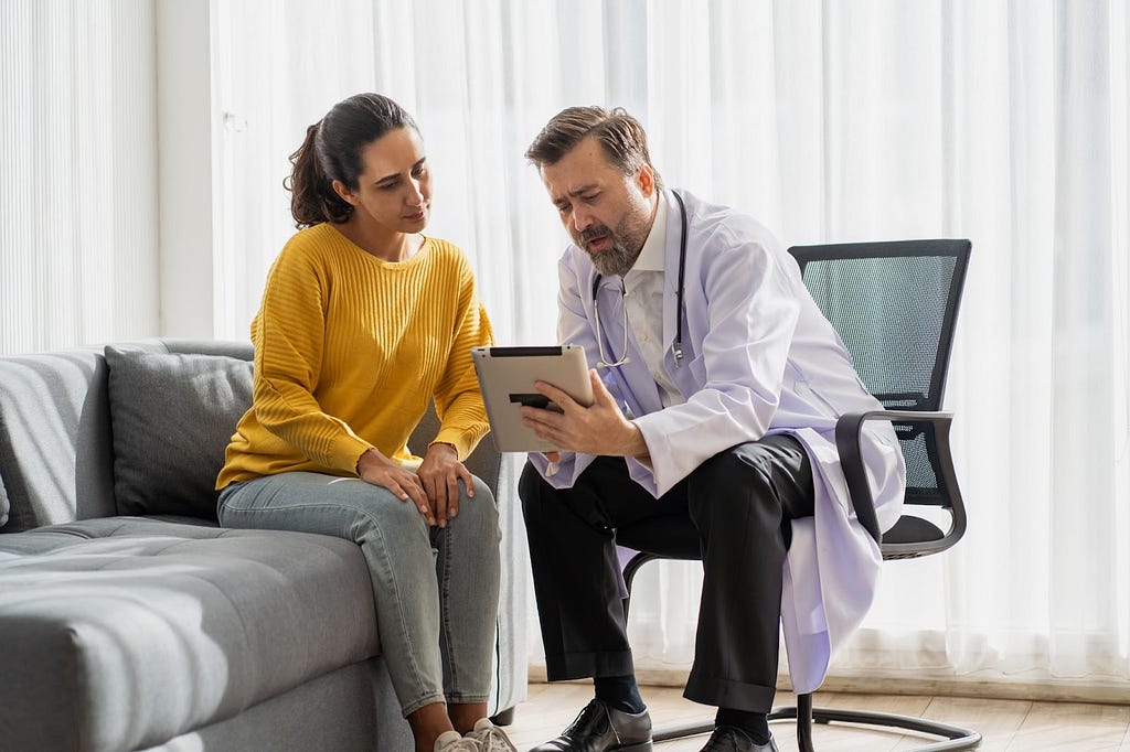 Doctor talking with patient about genetic test results, referencing electronic health records (EHRs)