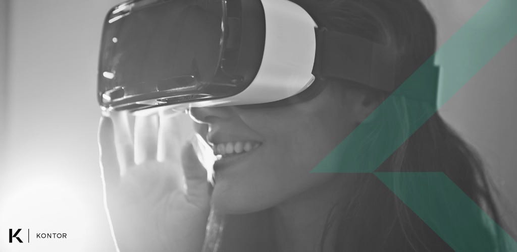 Person with long hair wearing a VR white and black VR headset, smiling. The image is black and white, with a green lines on top if it. The Kontor logo is in the bottom-left corner.