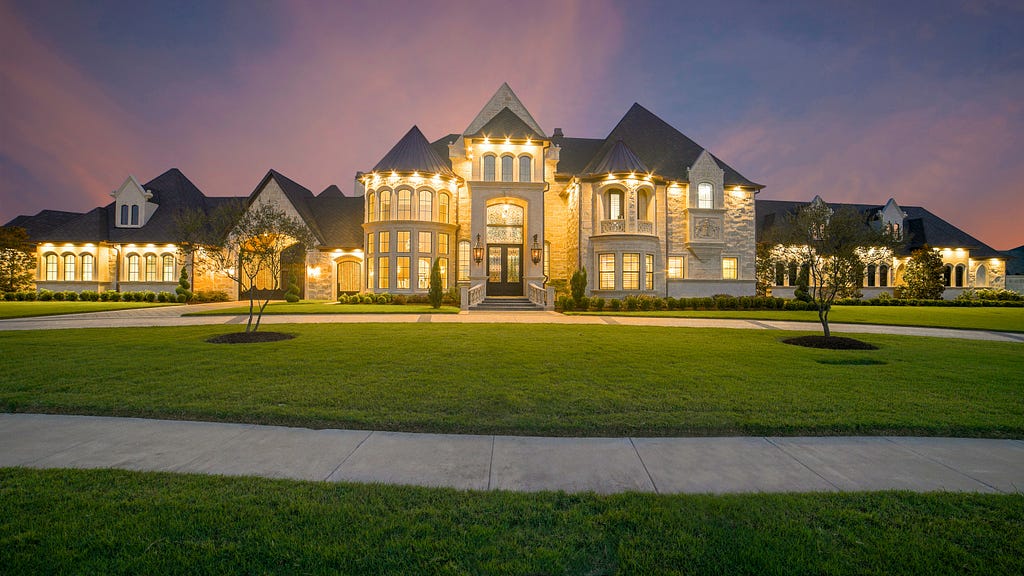 A long, sprawling house lit up at dusk.