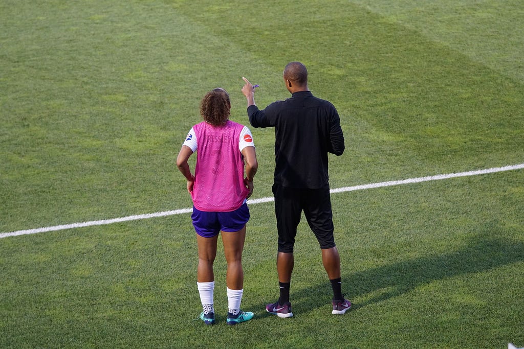 a coach and soccer player on the field