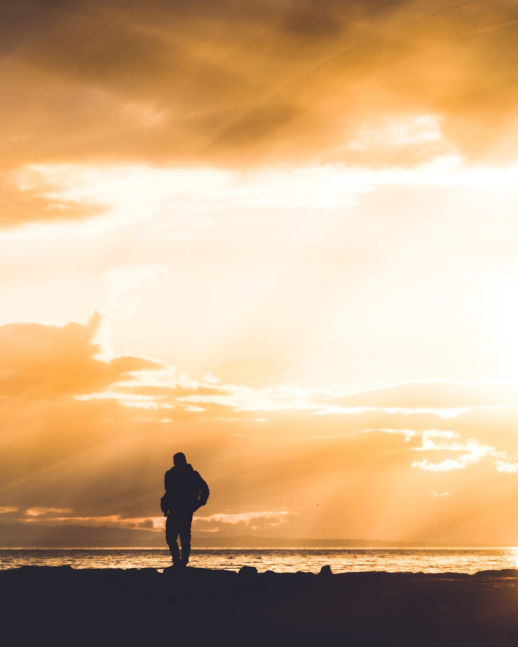 A man walking alone on a beach.