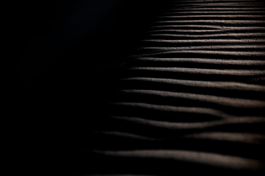 dark image of waves on sand