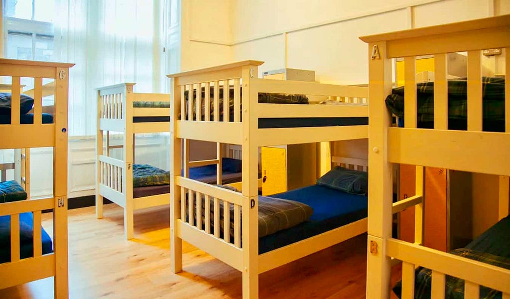 A spacious and bright dorm room with lots of wooden bunk beds at Edinburgh Backpackers in Scotland