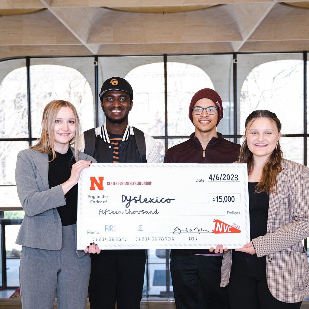 Students hold up a check for their winning pitch during the Center for Entrepreneurship’s annual New Venture Competition.