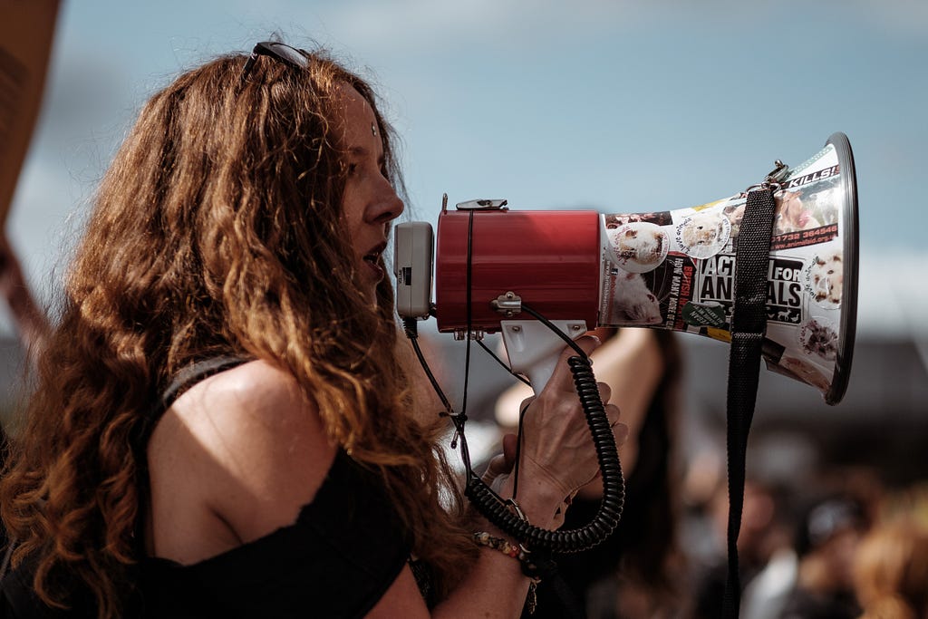 Woman with megaphone covered in stickers