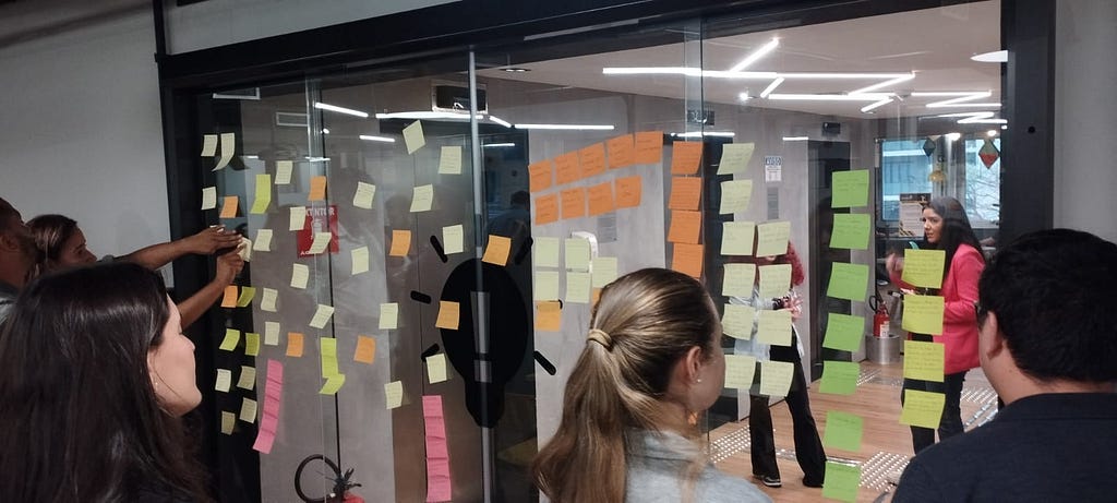 Post-its de ideação sendo colados em portas de vidro por clientes