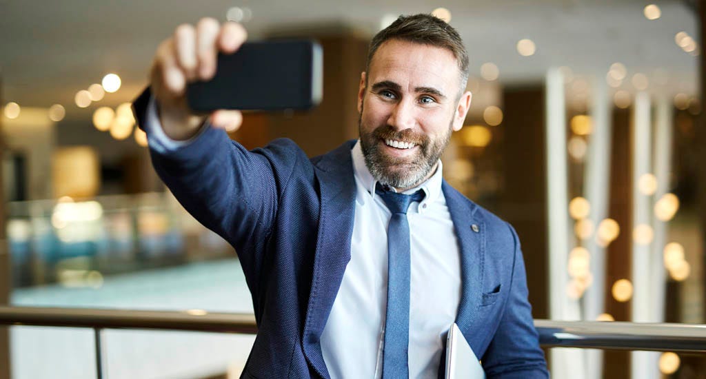 Confident entrepreneur taking selfie for social media