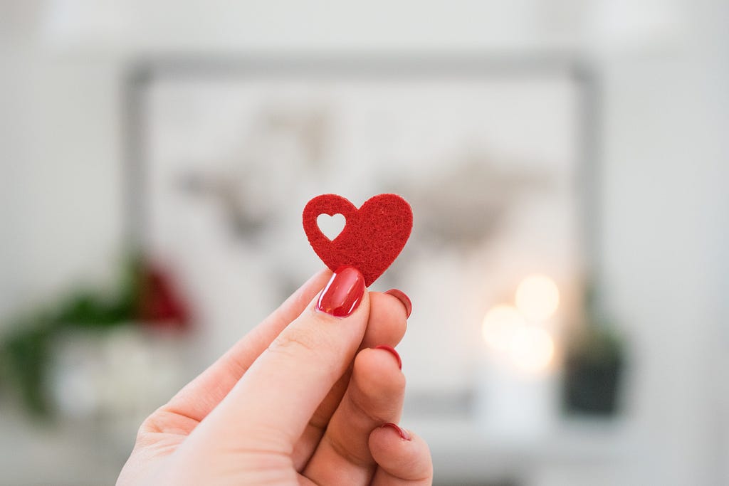 a person holding a tiny valentine heart