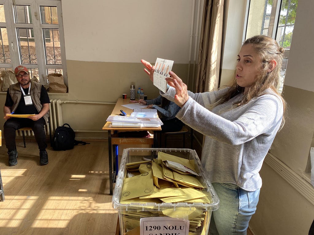 A woman showing the vote results to election observers