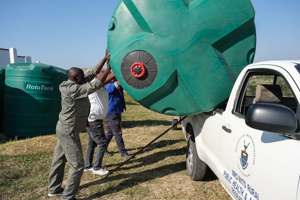 Staff loading one of 55 5,000-liter water tanks that were distributed to local communities in Agincourt as part of Variant Bio’s benefit-sharing initiative.