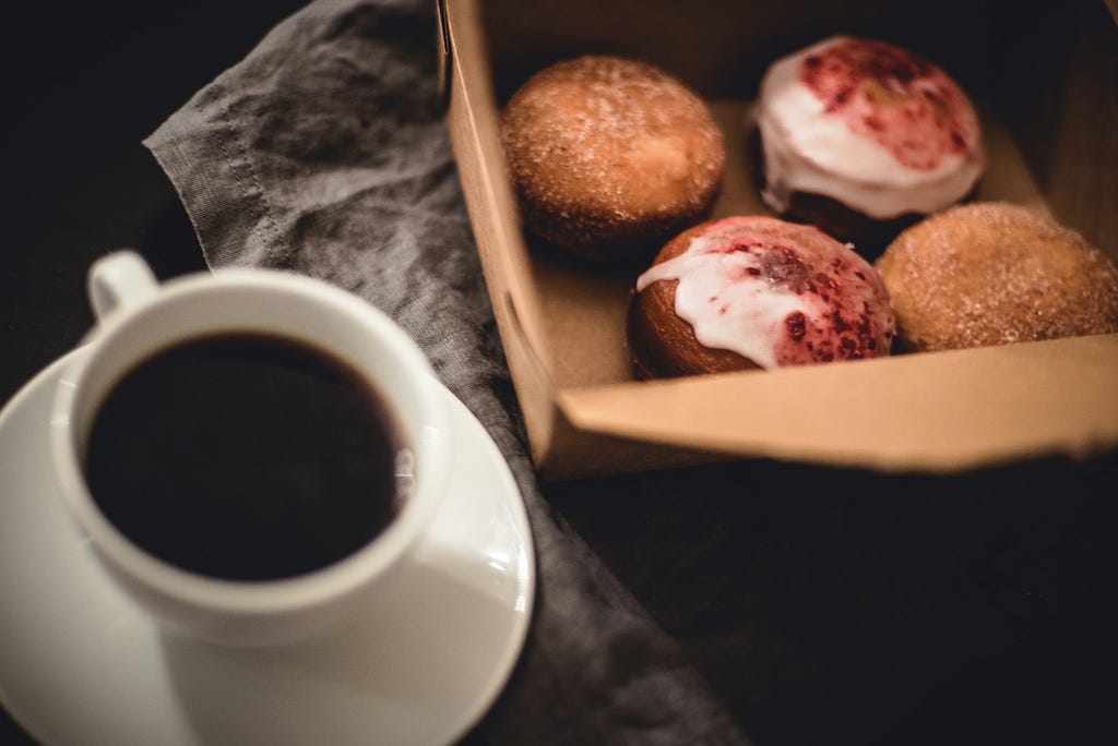 coffee and box of glazed doughnuts