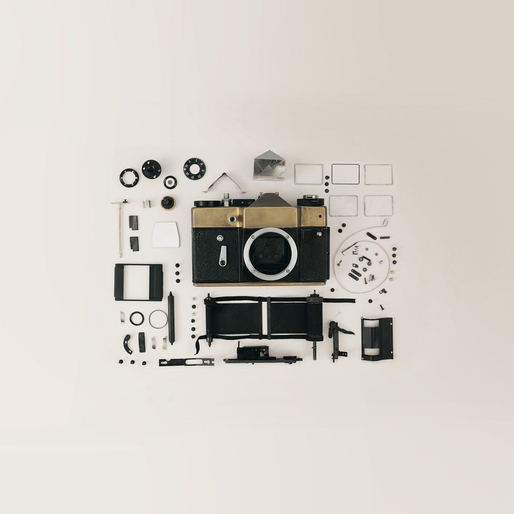 A camera that has been taken apart and all pieces carefully organized