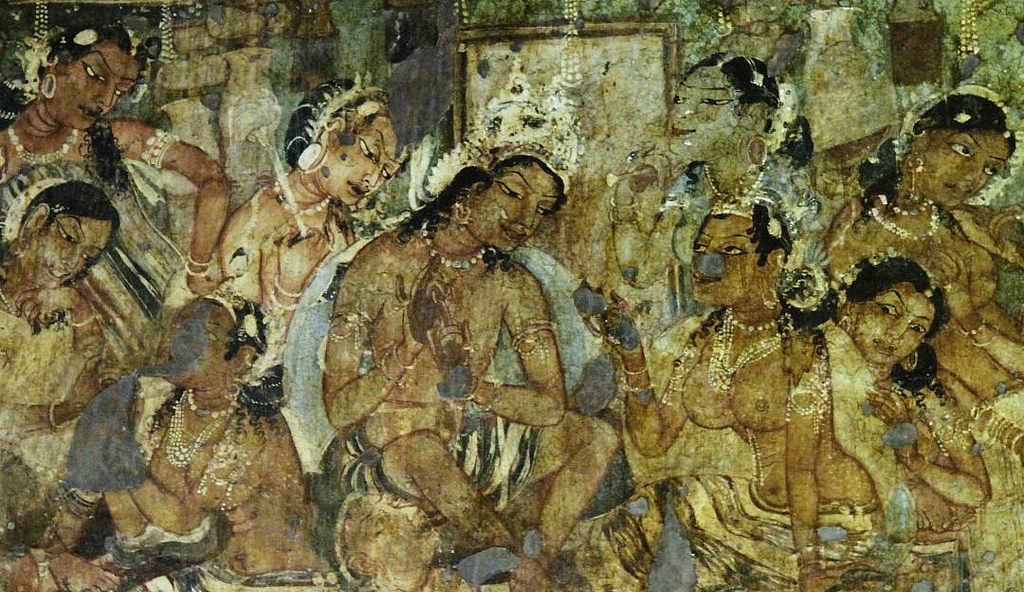 Ancient Indian fresco depicting a group of women adorned in jewelry, with intricate hairstyles and elaborate clothing. They are seated and engaged in a ceremonial or devotional activity, surrounded by other figures. The women have graceful expressions, and some are seen holding objects, possibly ritual items. The painting shows soft earth tones with delicate detailing, reflecting the artistic style of the Ajanta Caves, a UNESCO World Heritage site known for its Buddhist cave paintings.