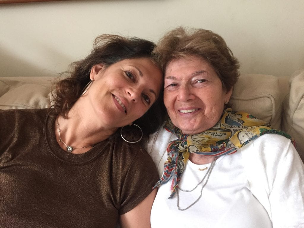 Mother and daughter still smiling despite: Alzheimer's parent sibling conflict.
