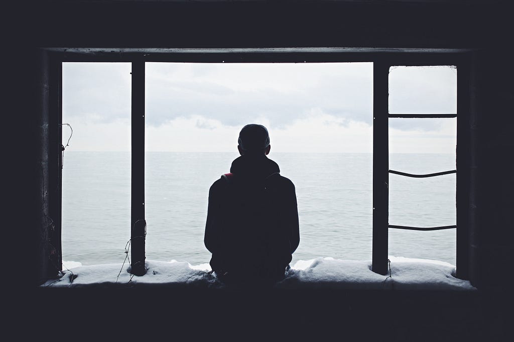 a single person looks out over the horizon of an ocean