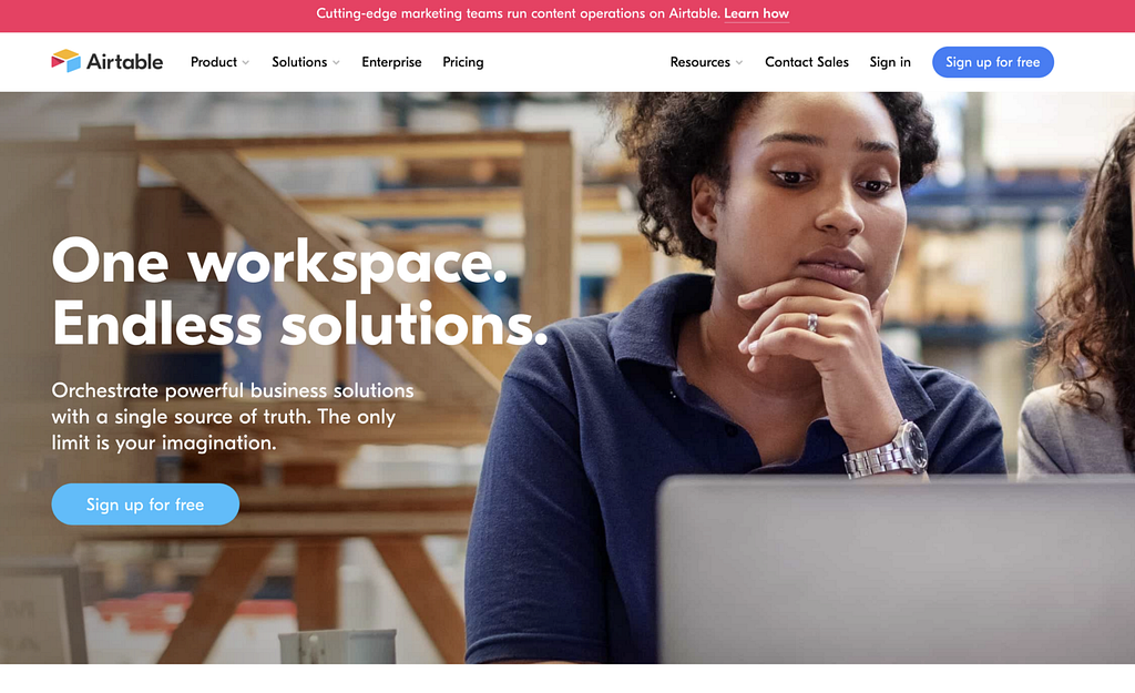 Airtable’s home page with a person looking at a laptop screen