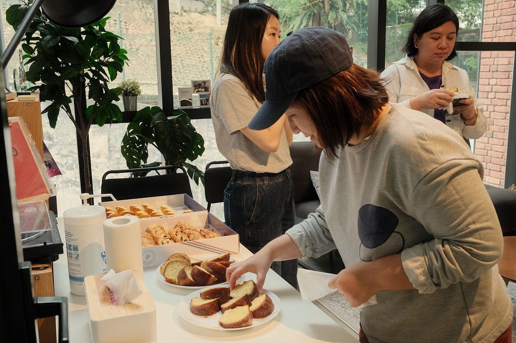 A woman getting a slice of cake from a plate