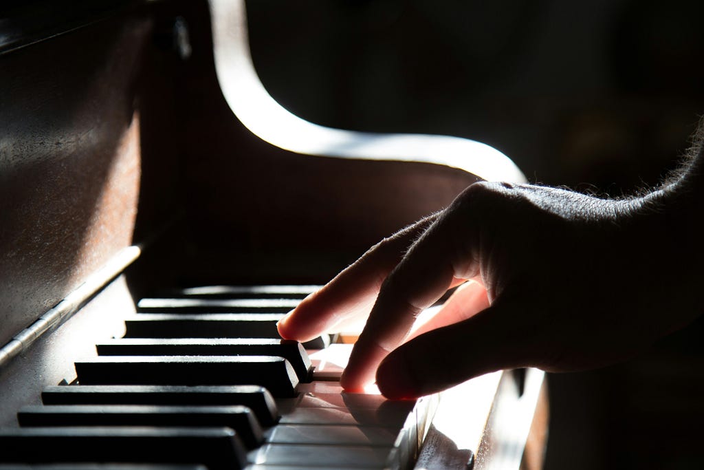 Piano player with a light shining on hand