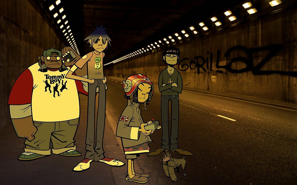 Membros virtuais da banda Gorillaz (Russel, 2D, Noodle e Mordec) em um túnel de uma rua, com “Gorillaz” pichado numa das paredes do túnel atrás deles.