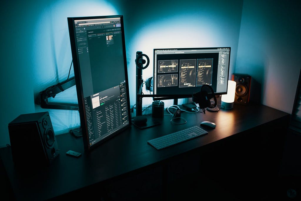 Two monitors and a keyboard in a home office workstation