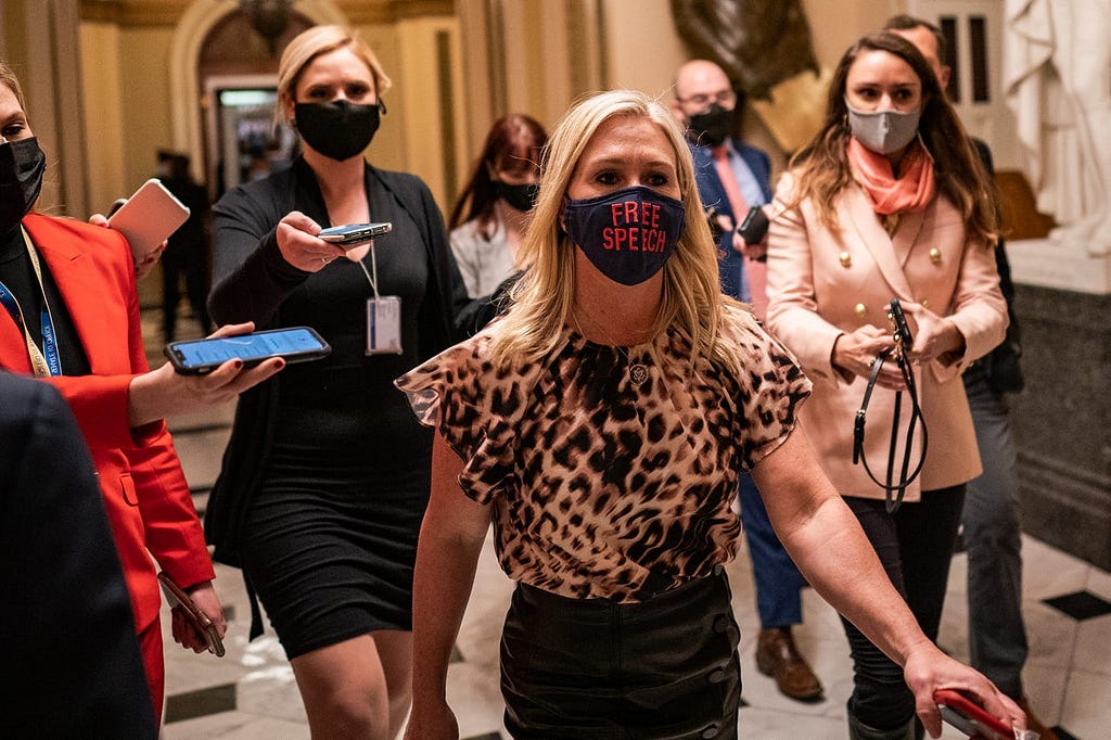 Greene wearing a “Free Speech” face mask as she walks through the halls of Congress, tailed by reporters, on February 2, 2021.