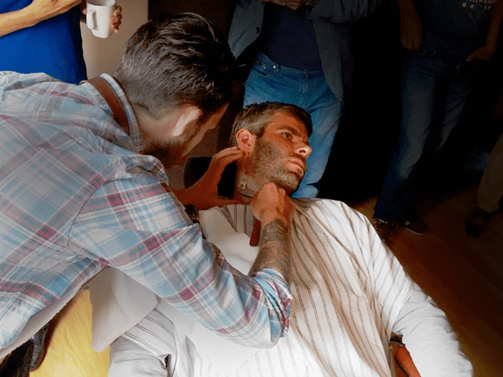 Photo of a barber shaving a software engineer, at our Philips Grooming hackathon
