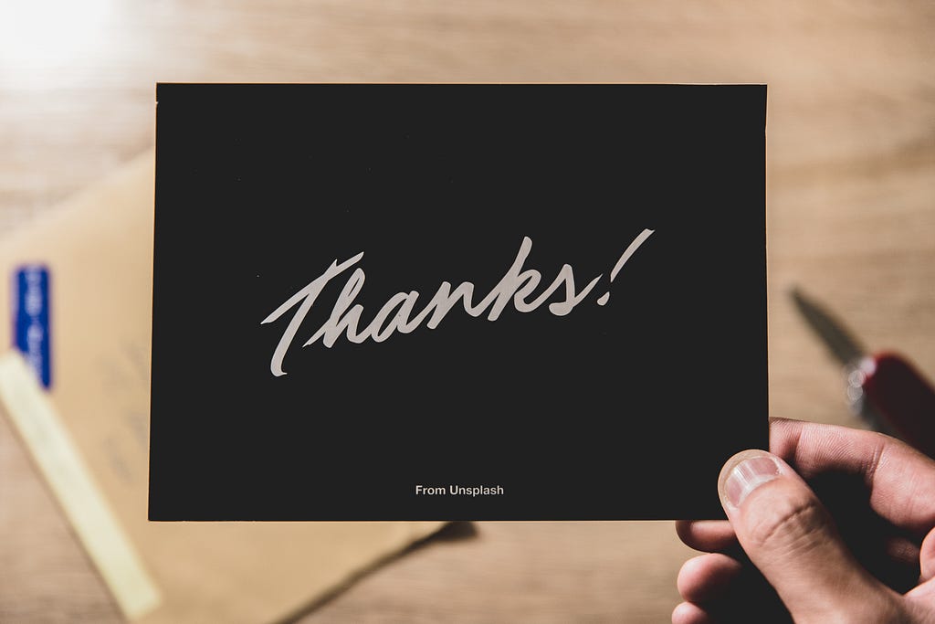 Hand holding a thank you card.