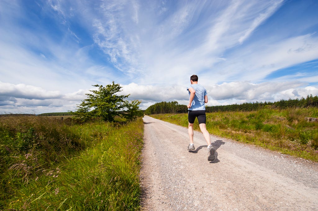 A runner out for a run on a country road.