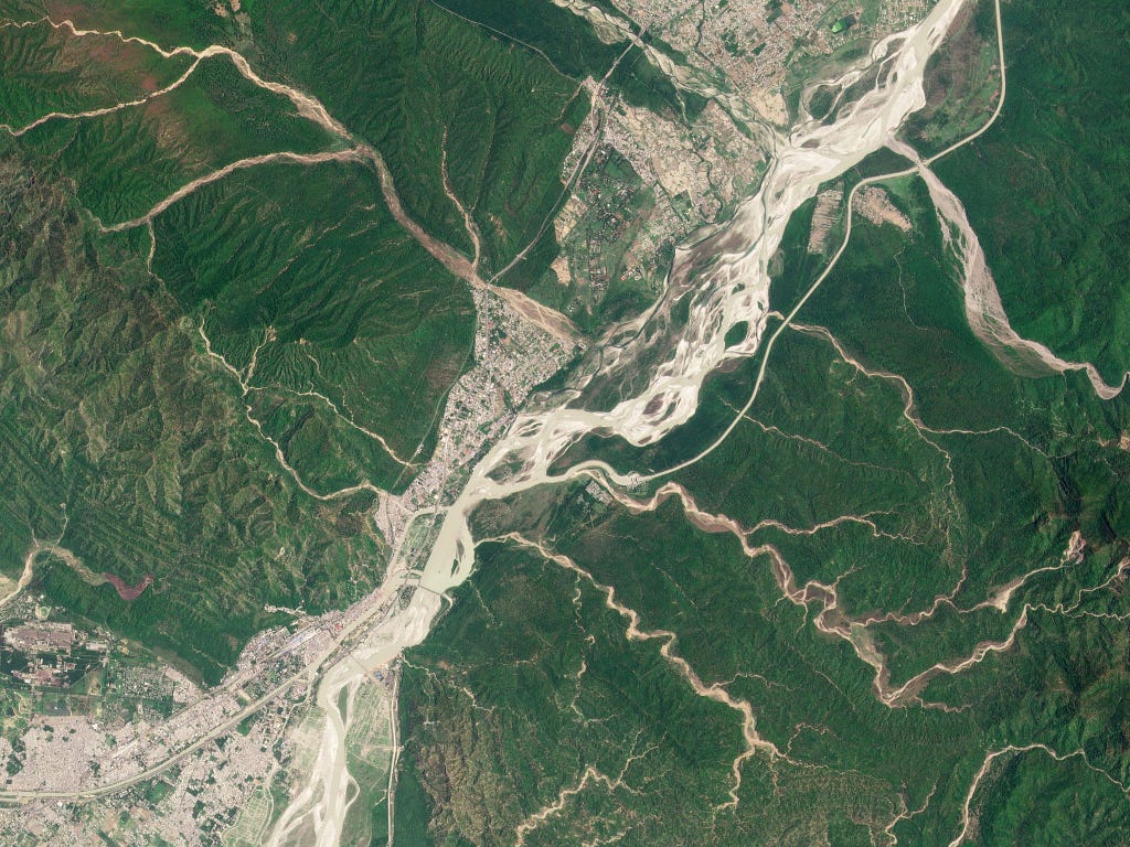 The Ganges River bisects two districts of the Rajaji National Park, alongside densely populated neighborhoods of Haridwar, India. June 2021. PlanetScope.