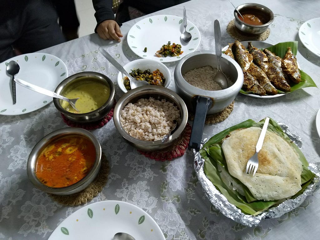 A South Indian fish meal with curries, rice, appams and fried fish