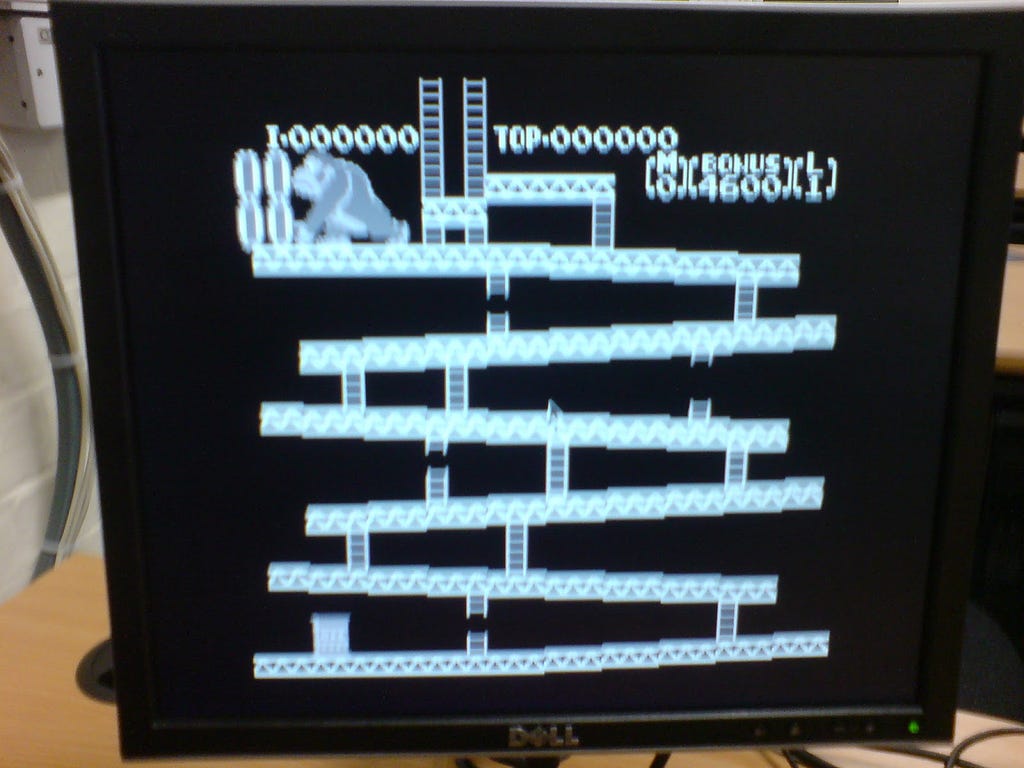 A computer monitor displaying the Nintendo game Donkey Kong in black and white, with the platforms and titular character in the top left but no other characters/sprites.
