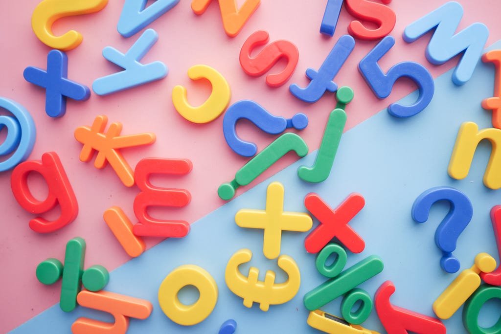 Plastic letter magnets scattered on a bright background.