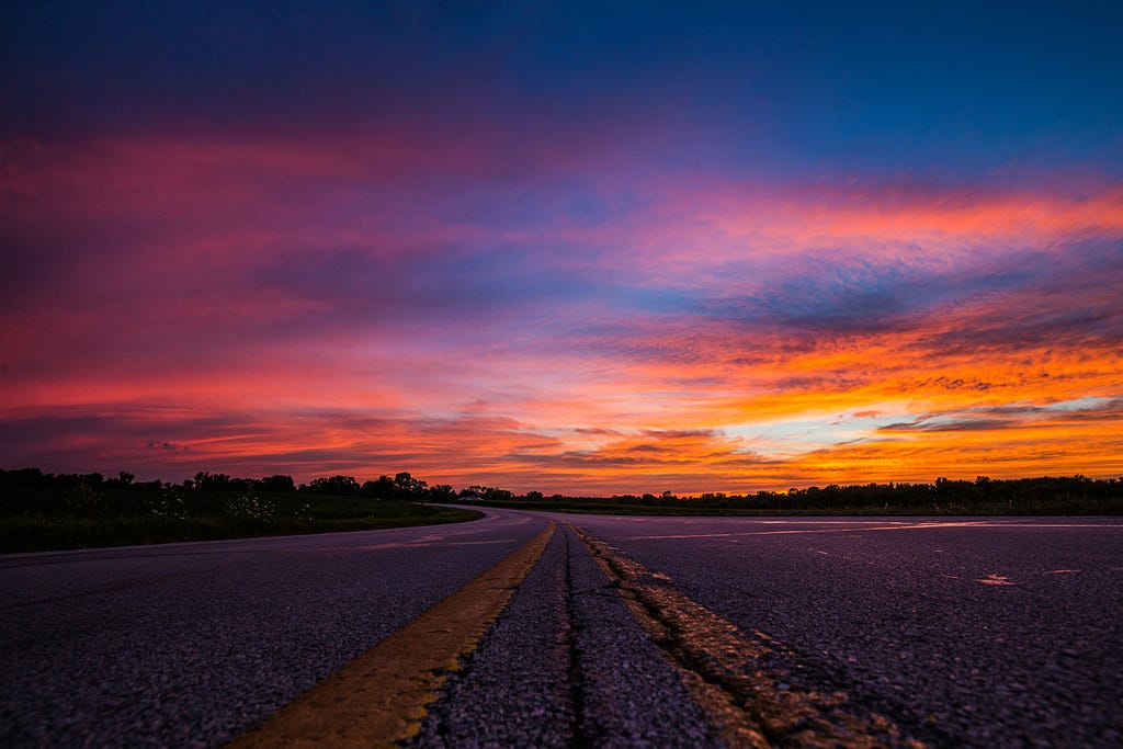 Brilliant pink and orange sunset taken from vantage point of highway