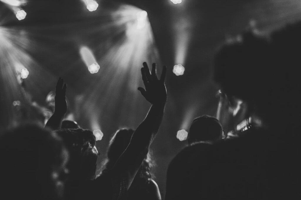 A black and white scene of adoring fans at a concert