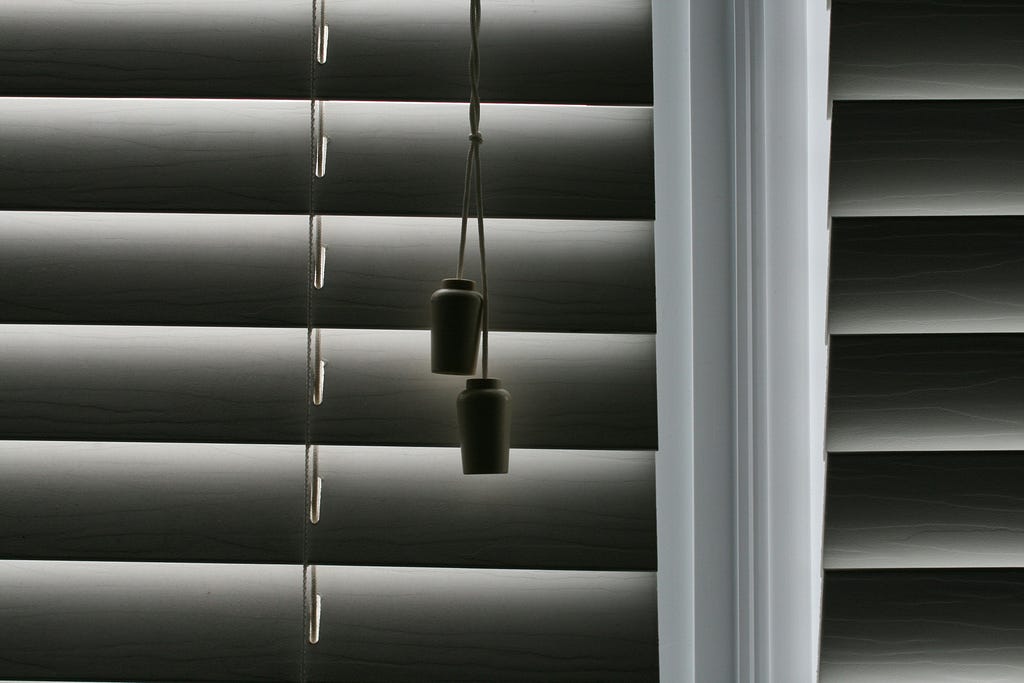 Close up of window blinds, focused on toggle to open and close them