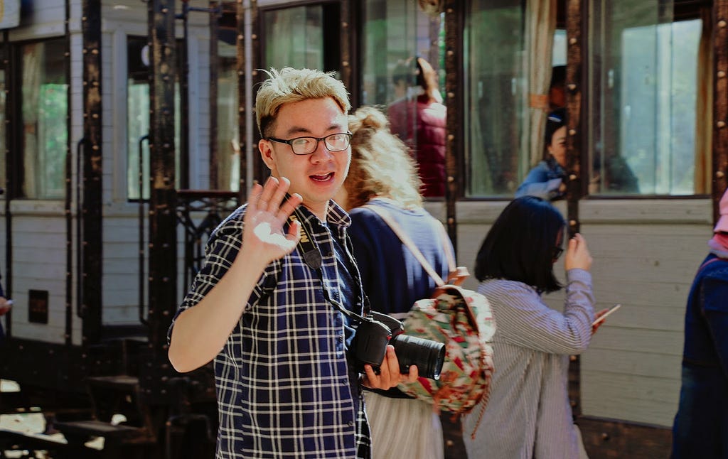 Man holding camera politely waving goodbye