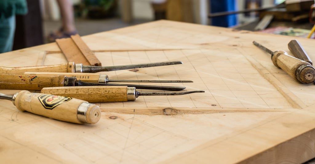 different types of chisels lying on a woodworking worktable