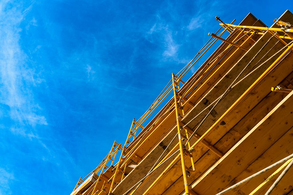 A photo of a building being erected against a deep blue sky.