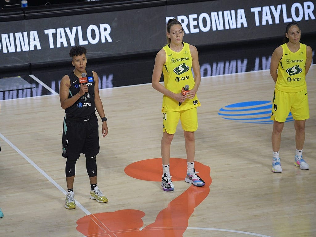 Layshia Clarendon (left) speaks alongside Breanna Stewart (middle) and Sue Bird (right) about the “Say Her Name” campaign.