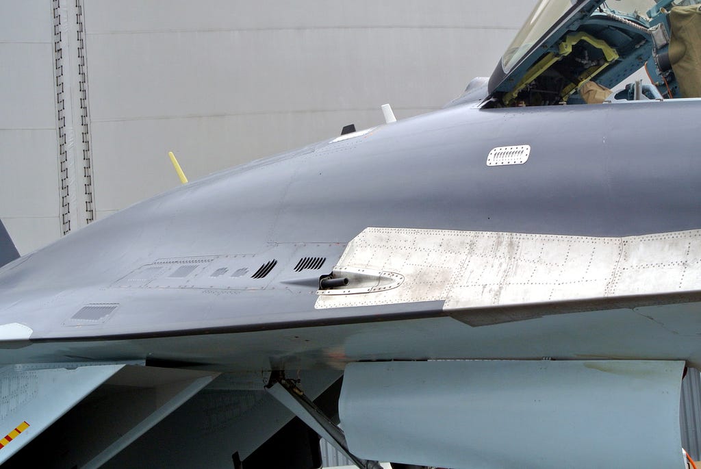 Su-35 gun exposed, also on the dorsal side near its wing root. Other aircraft of the Su-27 family feature a gun port in the same position