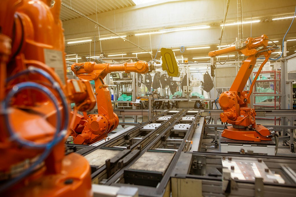 Industrial robots in a modern factory automate production processes, illustrating the combination of AI and RPA for enhanced efficiency, accuracy, and insights in 2024