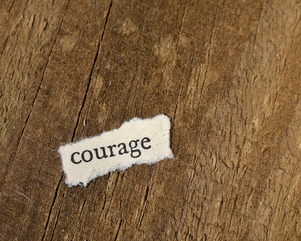 Piece of paper with “courage” written on it on the ground