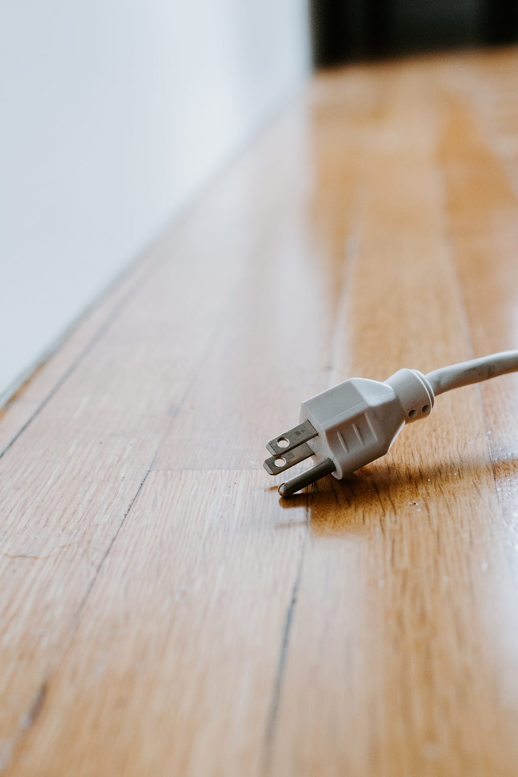 a white plug on a wooden floor