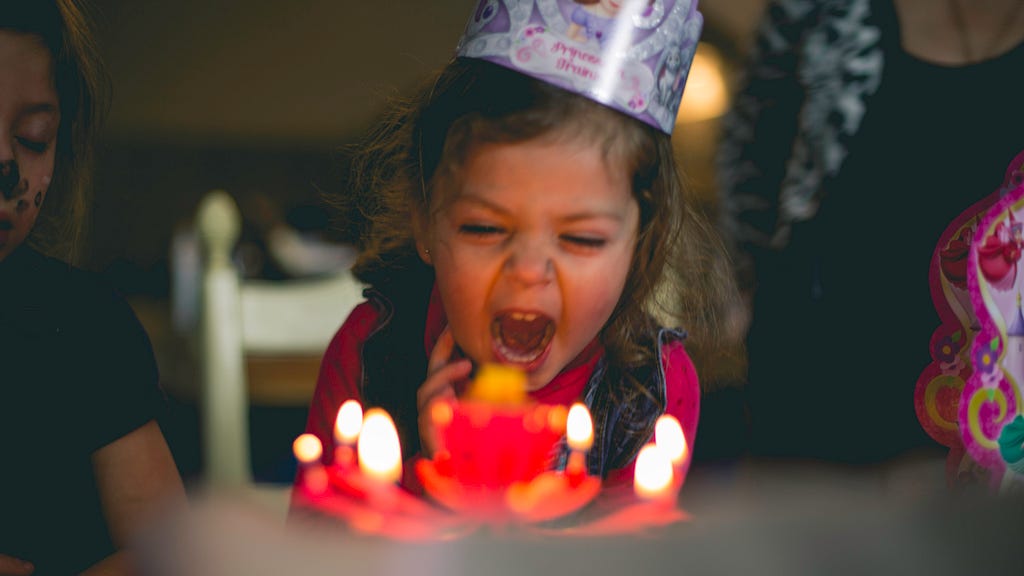 a child screaming at her birthday cake