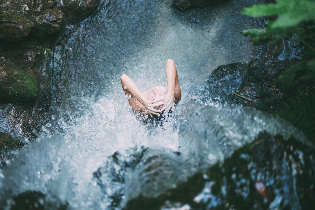 Woman showering in waterfall