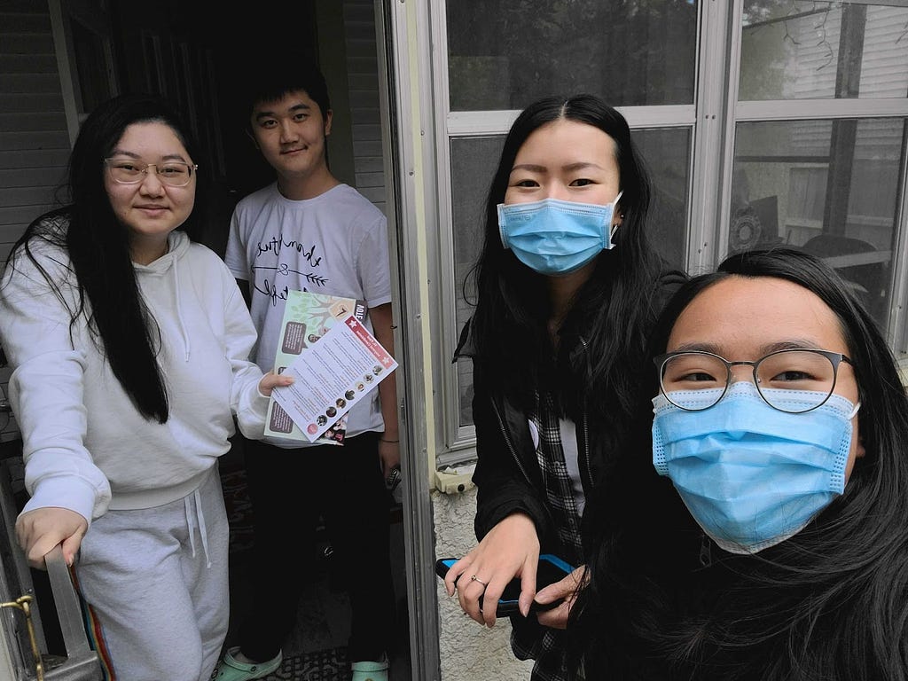 Gender Justice Coordinator Michelle (right, masked) with Youth Program Manager Clara (right, masked) as they speak with community members in St. Paul about the 2021 elections.